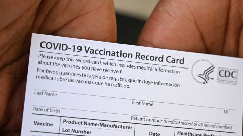 A healthcare worker displays a Covid-19 Vaccination Record Card during a vaccine and health clinic at QueensCare Health Center in a predominately Latino neighborhood in Los Angeles, California, August 11, 2021. - All teachers in California will have to be vaccinated against Covid-19 or submit to weekly virus tests, Governor Gavin Newsom announced on August 11, as authorities grapple with exploding infection rates. The number of people testing positive for the disease has surged in recent weeks, with the highly infectious Delta variant blamed for the bulk of new cases. (Photo by Robyn Beck / AFP) (Photo by ROBYN BECK/AFP via Getty Images)