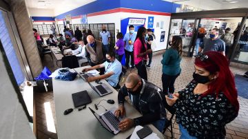 Applicants receive help with their applications during a job fair at a Post Office in Los Angeles, California on September 30, 2021, as the US Postal Service looks to fill 40,000 seasonal-worker positions in preparation for the winter holidays. - Mail delivery across the United States will slow down beginning October 1st as the US Postal Service implements new service standards. (Photo by Frederic J. BROWN / AFP) (Photo by FREDERIC J. BROWN/AFP via Getty Images)