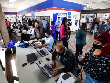 Applicants receive help with their applications during a job fair at a Post Office in Los Angeles, California on September 30, 2021, as the US Postal Service looks to fill 40,000 seasonal-worker positions in preparation for the winter holidays. - Mail delivery across the United States will slow down beginning October 1st as the US Postal Service implements new service standards. (Photo by Frederic J. BROWN / AFP) (Photo by FREDERIC J. BROWN/AFP via Getty Images)