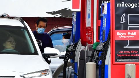 People get gas at a petrol station as prices rise above $5.00 a gallon in Los Angeles, California on March 4, 2022. - Californians filling up their cars on March 4, 2022, winced at the spiraling cost of gasoline, but largely shrugged as residents of the state that has long had the highest gas prices in the United States. (Photo by Frederic J. BROWN / AFP) (Photo by FREDERIC J. BROWN/AFP via Getty Images)