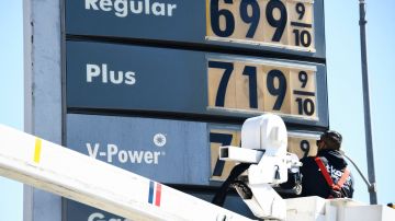 An electrical contractor repairs a sign with gasoline fuel prices above six and seven dollars a gallon at the Shell gas station at Fairfax and Olympic Blvd in Los Angeles, California, on March 8, 2022. (Photo by Patrick T. FALLON / AFP) (Photo by PATRICK T. FALLON/AFP via Getty Images)
