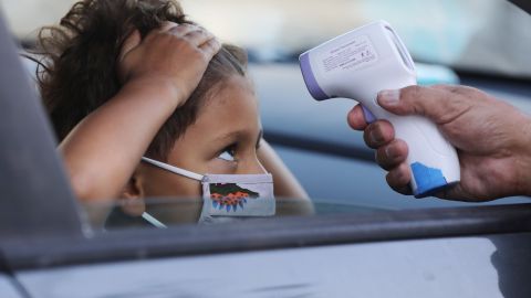 CULVER CITY, CALIFORNIA - SEPTEMBER 02: A student receives a temperature check before leaving the car to enter STAR Eco Station Tutoring & Enrichment Center on September 2, 2020 in Culver City, California. The center serves as a learning hub for students from various schools in the region which remain closed for In-person classes amid the COVID-19 pandemic. (Photo by Mario Tama/Getty Images)