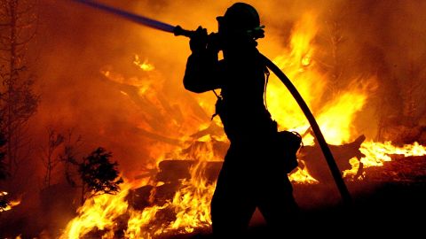 LOS ANGELES - OCTOBER 28: A firefighter struggles to battle the Crestline Wildfire that has swept through the area in Los Angeles County October 28, 2003 near Los Angeles, California October 28, 2003 near Los Angeles, California. The wildfires have burned over 300,000 acres devouring more than 600 homes and taking at least 13 lives. (Photo by Carlo Allegri/Getty Images)