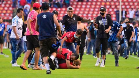 Un aficionado de Atlas protege a una persona en el campo de juego.