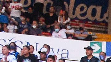 Aficionados de Querétaro saltándose una reja.