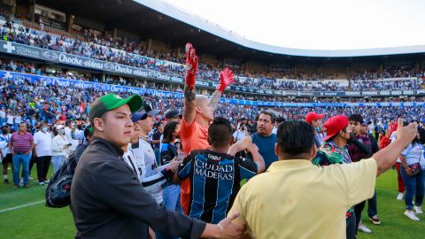 Washington Aguerre rodeado de aficionados que invadieron la cancha.