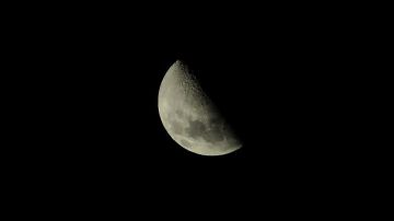 La luna en cuarto creciente se caracteriza por lucir mitad oscura y mitad iluminada.