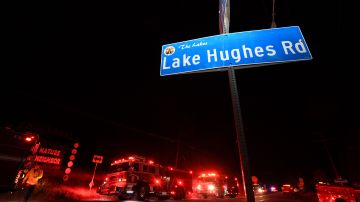 A fire fighter walks by fire trucks at the crossing of North Lake Hughes Road and Pine Canyon Road in the Angeles National Forest, by Lake Hughes, 60 miles north of Los Angeles, California on August 12, 2020. - A fast-moving brush fire north of Los Angeles prompted mandatory evacuation orders for some 500 homes on August 12 as firefighters battled the flames that had burned 10,000 acres by early evening, authorities said. The Lake Fire erupted at around 3:30 pm near Lake Hughes, about a 90-minute drive from Los Angeles. The blaze initially scorched 50 acres before exploding to 10,000 acres within a little more than three hours, according to the Los Angeles County Fire Department. (Photo by Robyn Beck / AFP) (Photo by ROBYN BECK/AFP via Getty Images)