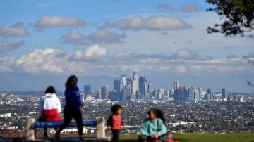 People enjoy the sunny afternoon on New Year's Eve in a Los Angeles park with a view of the downtown skyline, December 31, 2021. (Photo by Chris DELMAS / AFP) (Photo by CHRIS DELMAS/AFP via Getty Images)