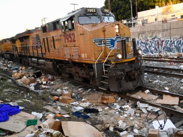 A Union Pacific locomotive passes through a section of tracks littered with thousands of opened boxes and packages stolen from cargo shipping containers, targeted by thieves as the trains stop in downtown Los Angeles, California on January 14, 2022. - Dozens of freight cars are broken into every day in Los Angeles by thieves who take advantage of their stops to loot the packages they carry, leaving thousands of stale boxes and internet-bought goods on the tracks that will never reach their destination. According to the labels found Friday by a team of AFP on a track near downtown, easily accessible from nearby streets, most of the major U.S. mail order and courier companies (Amazon, Target, UPS, Fedex, etc.) were affected by these thefts that have exploded in recent months. (Photo by Patrick T. FALLON / AFP) (Photo by PATRICK T. FALLON/AFP via Getty Images)
