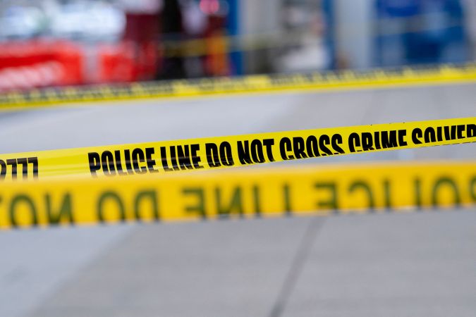 Police tape is seen as Manuel Oliver displays a banner calling on government officials to prioritize gun violence prevention from a construction crane near the White House in Washington, DC, on February 14, 2022. - Olivers son Joaquin Oliver was killed in the Parkland School shooting four years ago today. (Photo by Stefani Reynolds / AFP) (Photo by STEFANI REYNOLDS/AFP via Getty Images)