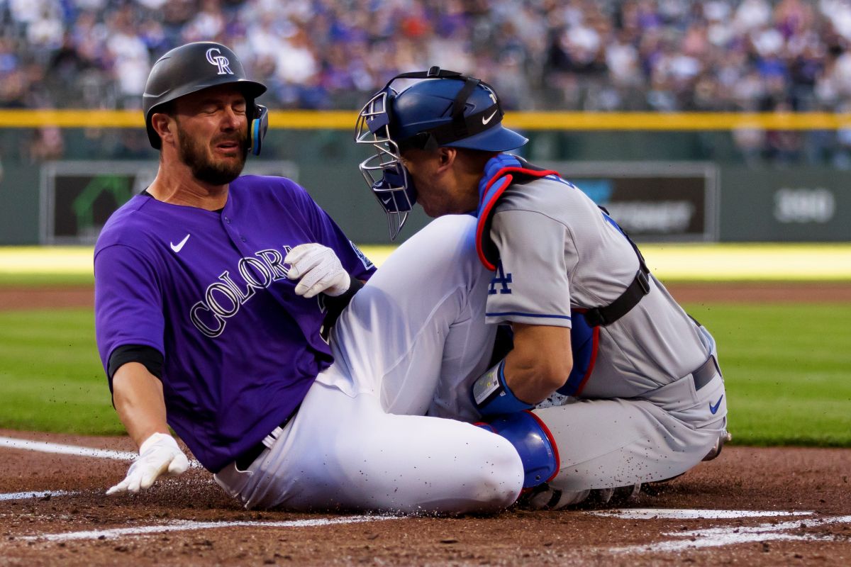 Kris Bryant anota para los Rockies tras la colisión con el catcher Austin Barnes, de los Dodgers.