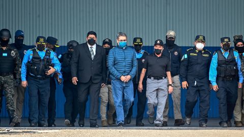 El expresidente Juan Orlando Hernandez (C) escoltado por autoridades de Honduras para su extradición