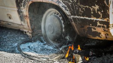 An ember burns under a car destroyed by the Clayton Fire in Lower Lake, California, August 15th, 2016. A northern California wildfire grew rapidly over the weekend, destroying homes and forcing 4,000 residents to flee, authorities said. / AFP / GABRIELLE LURIE (Photo credit should read GABRIELLE LURIE/AFP via Getty Images)