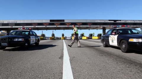 OAKLAND, CA - OCTOBER 28: California Highway Patrol officer Rick Baller walks to his car as he guards the closed toll plaza leading to the San Francisco Bay Bridge October 28, 2009 in Oakland, California. The San Francisco Bay Bridge was abruptly closed Tuesday evening after two steel tie rods and a crossbeam from a steel saddle broke and fell onto the upper deck of the bridge landing on three vehicles and causing one person to suffer injuries. The eastern span of the bridge is undergoing seismic renovation and is expect to be completed in 2013. (Photo by Justin Sullivan/Getty Images)