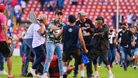 La afición invadió el campo durante el Querétaro vs. Atlas para evitar ser agredidos en las tribunas.
