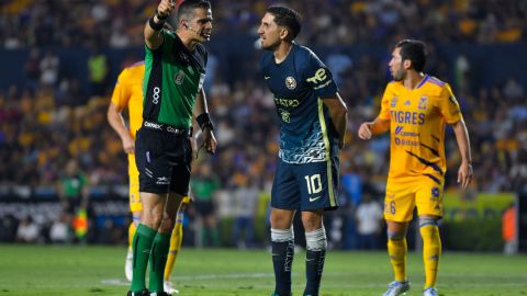 Diego Valdés (d), de las Águilas del América, le reclama al árbitro Fernando Hernández Gómez (i) tras anularle un gol ante Tigres UANL.