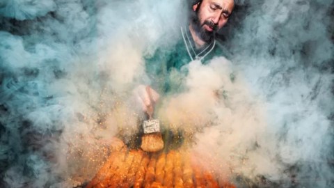 foto de un vendedor ambulante de comida trabajando en un horno cubierto de humo