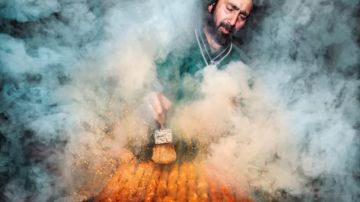 foto de un vendedor ambulante de comida trabajando en un horno cubierto de humo