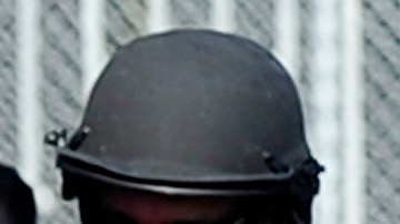 Police and sherriffs deputies maintain a command post outside Gardena High School in Los Angeles January 18, 2010 where two students suffered gunshot wounds after a pistol in a 10th-grader's backpack accidentally discharged when he dropped the bag. AFP PHOTO/Robyn BECK (Photo credit should read ROBYN BECK/AFP via Getty Images)