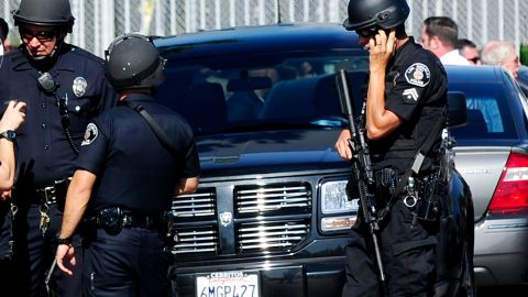 Police and sherriffs deputies maintain a command post outside Gardena High School in Los Angeles January 18, 2010 where two students suffered gunshot wounds after a pistol in a 10th-grader's backpack accidentally discharged when he dropped the bag. AFP PHOTO/Robyn BECK (Photo credit should read ROBYN BECK/AFP via Getty Images)