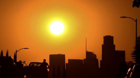People step into their vehicles as the sun sets over Los Angeles, California on September 30, 2020. - A heat advisory is in effect through Friday in the Southern California region where temperatures are expected to climb into triple-digits, according to the National Weather Service. (Photo by Frederic J. BROWN / AFP) (Photo by FREDERIC J. BROWN/AFP via Getty Images)