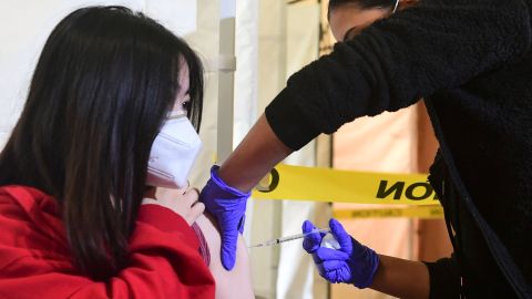 High school student Kelly Zhou, 17, receives her first Pfizer Covid-19 vaccine administered by Medical Assistants from St. John's Well Child and Family Center at Abraham Lincoln High School in Los Angeles on April 23, 2021. - In an ongoing effort to encourage students 16 and older to get vaccinated, Los Angeles County is offering free Covid-19 vaccines at large-scale vaccination sites over the weekend till Monday with walk-in innoculations available while supplies last. (Photo by Frederic J. BROWN / AFP) (Photo by FREDERIC J. BROWN/AFP via Getty Images)