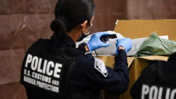 US Customs and Border Protection (CBP) officers demonstrate a physical inspection of seized goods believed to be counterfeit during an opening ceremony for a US Customs and Border Protection (CBP) air dedicated centralized examination station with Custom Specialized Services at Los Angeles International Airport (LAX) on September 16, 2021 in Los Angeles, California. - The new 40,000 sq foot facility is designed to expedite the screening of e-commerce shipments and cargo while intercepting illicit goods including counterfeit products and narcotics through a combination of new scanner technology and CBP officer inspections. (Photo by Patrick T. FALLON / AFP) (Photo by PATRICK T. FALLON/AFP via Getty Images)