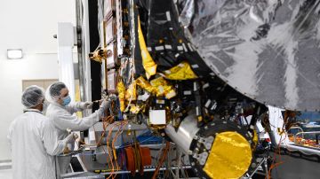 Workers prepare the Psyche spacecraft inside a clean room at NASA's Jet Propulsion Laboratory (JPL) in Pasadena, California, on April 11, 2022. - Psyche will launch from Cape Canaveral, Florida, in August 2022 to enter orbit in space around an asteroid, also named Psyche, in 2026 to study the metal-rich asteroid and learn more about it's origin and composition. (Photo by Patrick T. FALLON / AFP) (Photo by PATRICK T. FALLON/AFP via Getty Images)