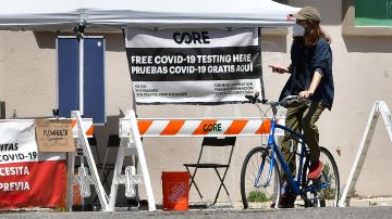 A cyclist rides past a Covid testing site in Los Angeles, California on April 15, 2022. - A new study shows the spread of Covid-19 in Los Angeles County is more widespread than testing has shown and among children, the numbers suggest five times more children were actually infected than testing confirmed. (Photo by Frederic J. BROWN / AFP) (Photo by FREDERIC J. BROWN/AFP via Getty Images)