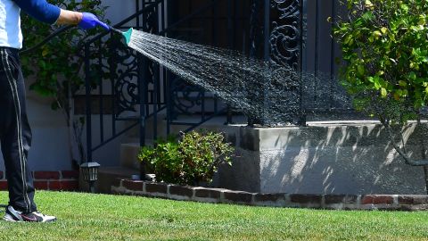 A man waters his lawn in Alhambra, California on April 27, 2022, a day after Southern California delared a water shortage emergency, with unprecedented new restrictions on outdoor watering for millions of people living in Los Angeles, San Bernardino and Ventura counties. - Southern California's Metropolitan water district will allow for outdoor watering tp just one day per week effective June 1st. (Photo by Frederic J. BROWN / AFP) (Photo by FREDERIC J. BROWN/AFP via Getty Images)