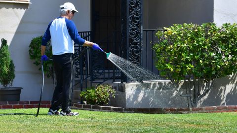 A man waters his lawn in Alhambra, California on April 27, 2022, a day after Southern California delared a water shortage emergency, with unprecedented new restrictions on outdoor watering for millions of people living in Los Angeles, San Bernardino and Ventura counties. - Southern California's Metropolitan water district will allow for outdoor watering tp just one day per week effective June 1st. (Photo by Frederic J. BROWN / AFP) (Photo by FREDERIC J. BROWN/AFP via Getty Images)