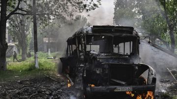 Un militar ucraniano camina junto a un vehículo en llamas destruido cerca de Lysychansk