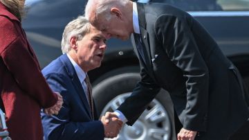 El gobernador republicano Greg Abbott saluda al presidente Joe Biden.
