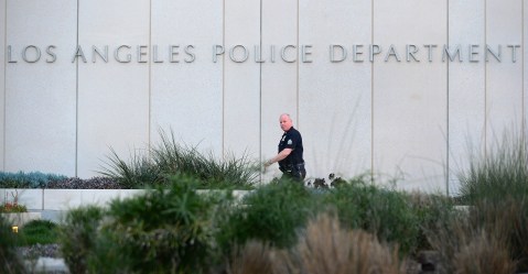 A Los Angeles Police Department (LAPD) officer walks to police headquarters in downtown Los Angeles on February 12, 2013 in California, where media are gathered in regards to the case of suspected cop killer Christopher Dorner. The LA Times reported a single gunshot was heard as police moved in on a mountain cabin where Dorner was believed to be barricaded in Big Bear, some 100 miles east of downtown Los Angeles. Meanwhile, a Los Angeles Police Department (LAPD) spokesman was cited as saying the force believed Dorner died inside the burning cabin in the mountains. AFP PHOTO / Frederic J. BROWN (Photo credit should read FREDERIC J. BROWN/AFP via Getty Images)