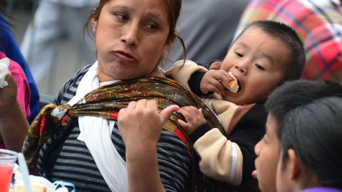 A woman feeds her children as the homeless on Skid Row are seated for the annual Good Friday meal hosted by the LA Mission and served by volunteers and celebrities on April 18, 2014 in Los Angeles, California. For more than 75 years, the LA Mission has helped serve the needs of the down and out in downtown Los Angeles, providing emergency service like shelter, food , clothing as well as professional medical and dental services. AFP PHOTO/Frederic J. BROWN (Photo credit should read FREDERIC J. BROWN/AFP via Getty Images)