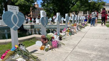 Personas visitan las cruces instaladas en memoria de las 21 víctimas asesinadas en la masacre de la escuela primaria Robb,