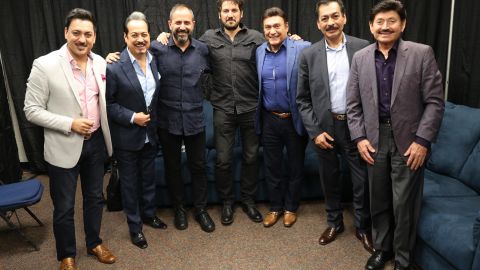 Los Tigres del Norte posan con el productor y el director (centro) del documental que narra su historia.