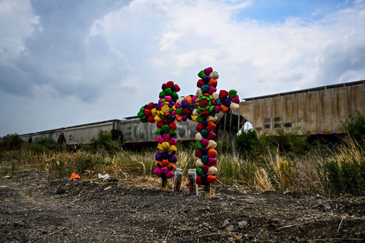 Cruz y velas se mantienen en el lugar donde se descubrió un camión con remolque con migrantes adentro, en las afueras de San Antonio, Texas.