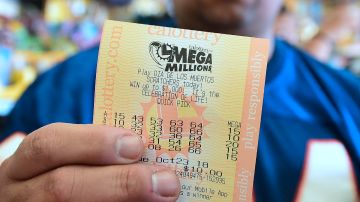 A man shows his just purchased lottery tickets from the Blue Bird Liquor store in Hawthorne, California on October 23, 2018 ahead of the drawing tonight for the Mega Millions jackpot, now reaching USD 1.6 billion. (Photo by Frederic J. BROWN / AFP) (Photo credit should read FREDERIC J. BROWN/AFP via Getty Images)