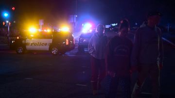 People walk away from the scene as it unfurls at the intersection of US 101 freeway and the Moorpark Rad exit as police vehicles close off the area responding to a shooting at a bar in Thousand Oaks, California on November 8, 2018. - Twelve people, including a police sergeant, were shot dead in a shooting at a night club close to Los Angeles, police said Thursday. All the victims were killed inside the bar in the suburb of Thousand Oaks late on Wednesday, including the officer who had been called to the scene, Sheriff Geoff Dean told reporters. The gunman was also dead at the scene, Dean added. The bar was hosting a college country music night. (Photo by Frederic J. BROWN / AFP) (Photo credit should read FREDERIC J. BROWN/AFP via Getty Images)