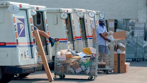 Postal workers sort, load and deliver mails as protesters hold a "Save the Post Office" demonstration outside a United States Postal Service location in Los Angeles, California, on August 22, 2020. - Postmaster General Louis DeJoy on August 21 denied claims he was working to undermine mail delivery, after comments by President Donald Trump raised fears the US Postal Service would be sabotaged to aid his chances in the November elections. (Photo by Kyle Grillot / AFP) (Photo by KYLE GRILLOT/AFP via Getty Images)