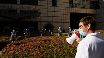 Dr. Mark Kelly speaks as healthcare workers wear face masks and carry signs in support of resident physicians, interns and fellows at UCLA Health as they protest for improved Covid-19 testing and workplace safety policies outside of UCLA Medical Center in Los Angeles, California, December 9, 2020. (Photo by Patrick T. Fallon / AFP) (Photo by PATRICK T. FALLON/AFP via Getty Images)