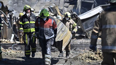 Trabajadores limpian los escombros del centro comercial que fue alcanzado por un ataque con misiles rusos en Kremenchuk.