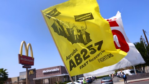 LOS ANGELES, CALIFORNIA - APRIL 16: Flags are flown at a car caravan and rally of fast food workers and supporters for passage of AB 257, a fast-food worker health and safety bill, on April 16, 2021 in the Boyle Heights neighborhood of Los Angeles, California. The rally was held outside of a McDonald’s location where a worker lodged public health complaints and a wage theft complaint. Some fast food workers are on strike in Los Angeles County today in support of the bill. (Photo by Mario Tama/Getty Images)