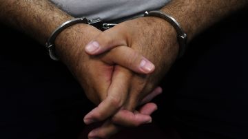 Detail of the hands of former Salvadoran President (2004-2009) Elias Antonio Saca with handcuffs, taken as he waits, along with six of his collaborators, for the judge to arrive in court in San Salvador on May 16, 2018, to face charges of embezzlement and laundering for allegedly diverting 298 million dollars. - Saca was arrested in October 2016 with his former private secretary and former communications secretary, among others, suspected of pocketing $246 million in public funds during his 2004-2009 mandate. They have been charged with embezzlement, criminal association and money laundering. (Photo by Marvin RECINOS / AFP) (Photo credit should read MARVIN RECINOS/AFP via Getty Images)