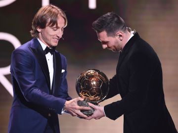 Luka Modric le entrega el Balón de Oro a Messi.