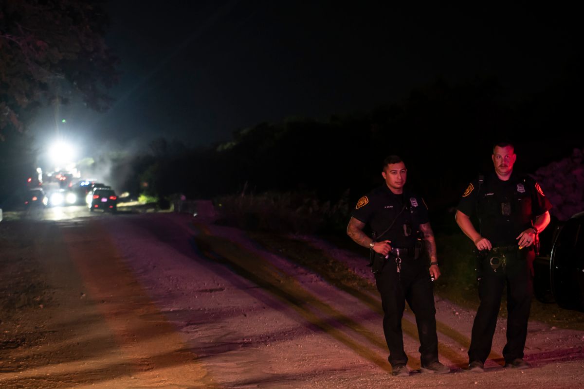 La policía vigila la escena donde se descubrió un camión con remolque con migrantes dentro de las afueras de San Antonio, Texas.