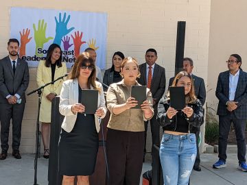 Araceli García, Ana Cristina Zamora y Deyanira Nolasco muestran las libretas que serán enviadas al Congreso. (Jacqueline García/La Opinión)