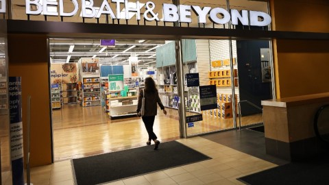 Una mujer cruza la entrada de una tienda de la marca de artículos para el hogar, Bed, Bath & Beyond.